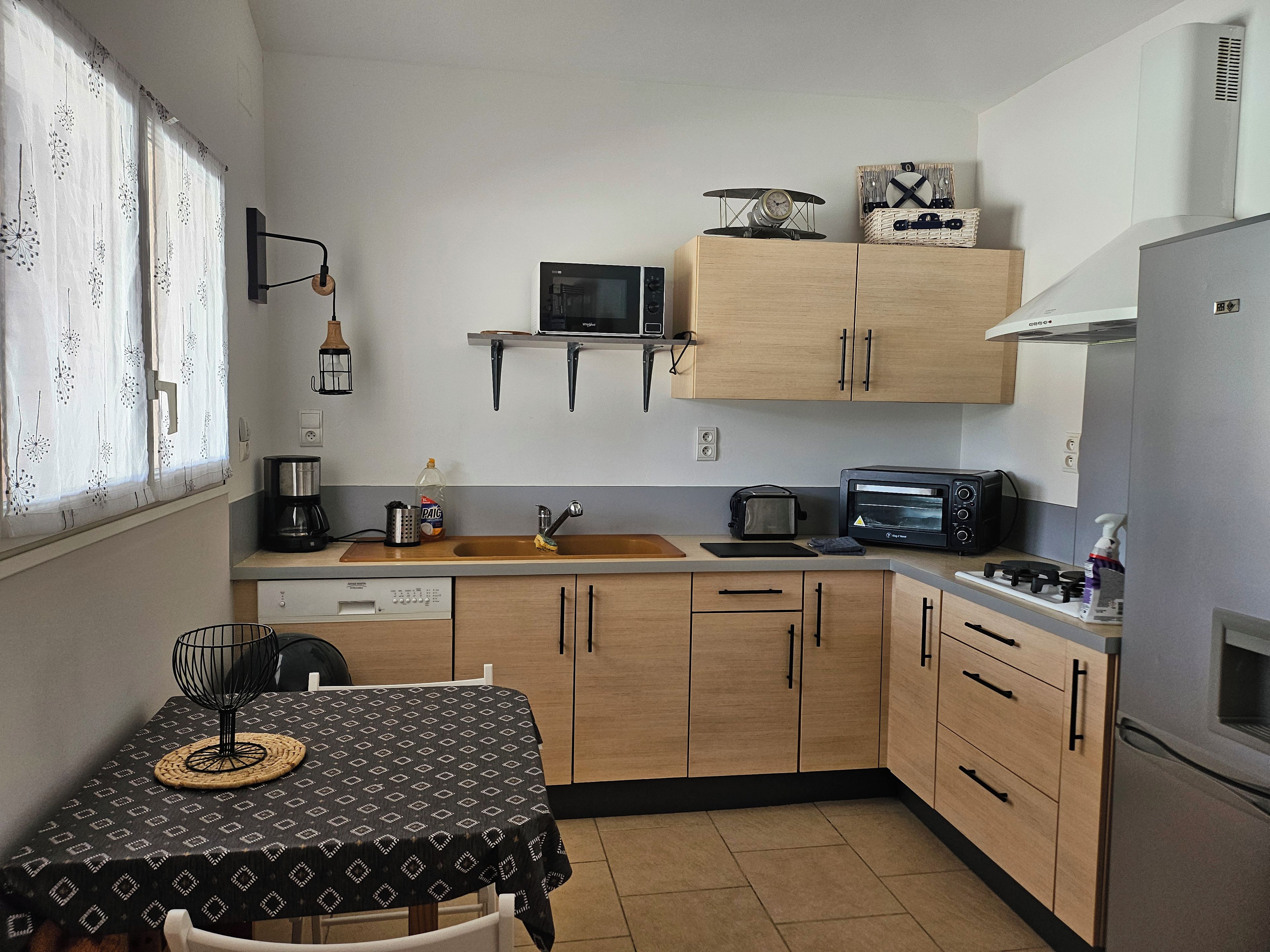 A compact kitchen with a microwave, toaster, and a small refrigerator.