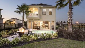 A two-story house with a balcony, a swimming pool, and a patio with outdoor furniture. - Beautiful 5 Star Villa on Reunion Resort and Spa with Large Private Pool, Orlando Villa 4597 (Orlando)