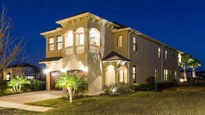 A two-story house with a balcony, a garage, and a well-maintained lawn. - Beautiful 5 Star Villa on Reunion Resort and Spa with Large Private Pool, Orlando Villa 4597 (Orlando)