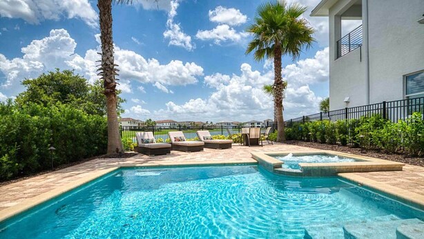 A swimming pool with lounge chairs, palm trees, and a clear sky. - Beautiful 5 Star Villa on Reunion Resort and Spa with Large Private Pool, Orlando Villa 4597 (Orlando)