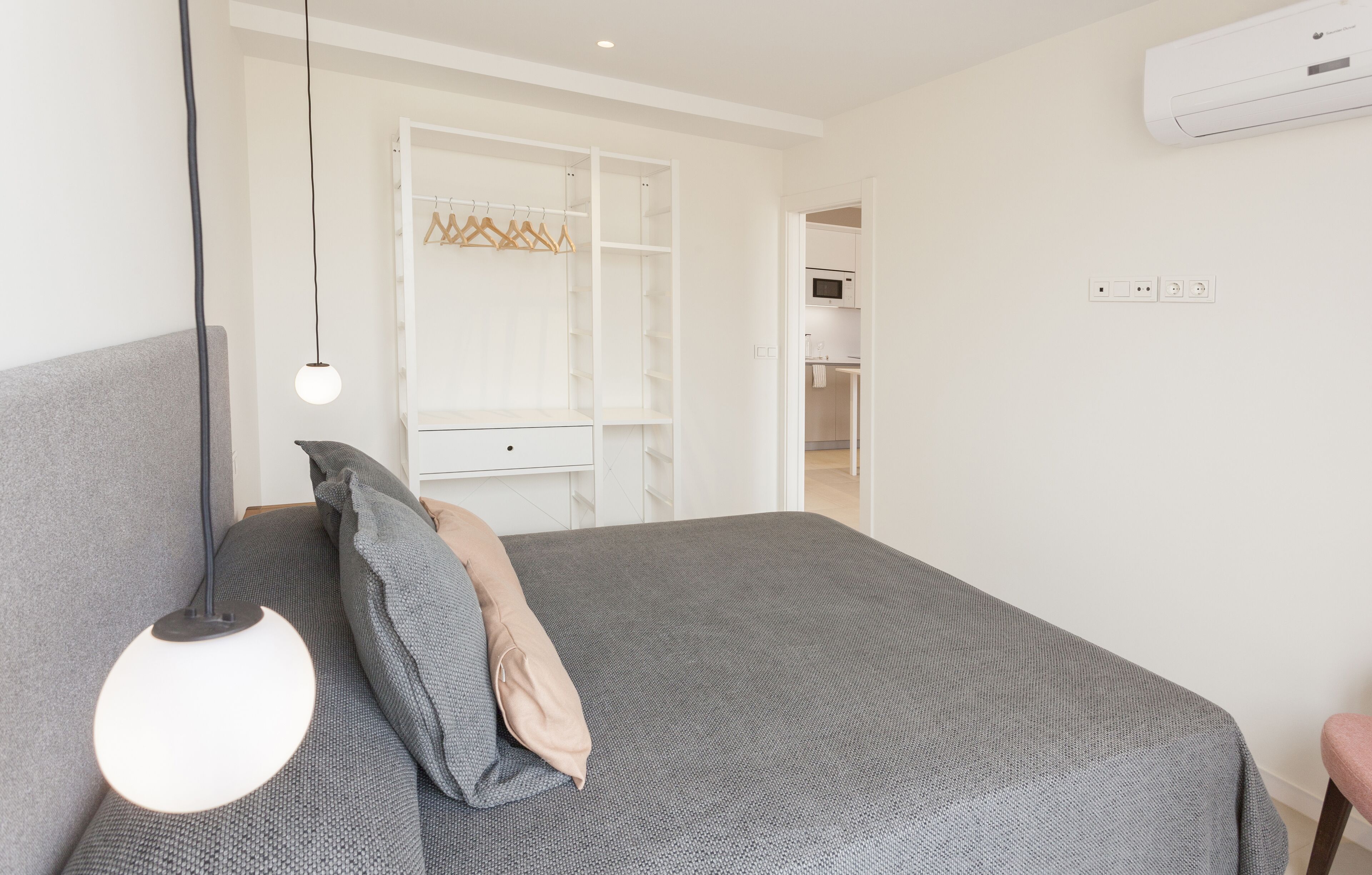 A bedroom with a bed, bedside lamp, and a walk-in closet.