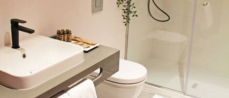 Une salle de bain moderne avec un lavabo blanc, un robinet noir et une douche à l’italienne.