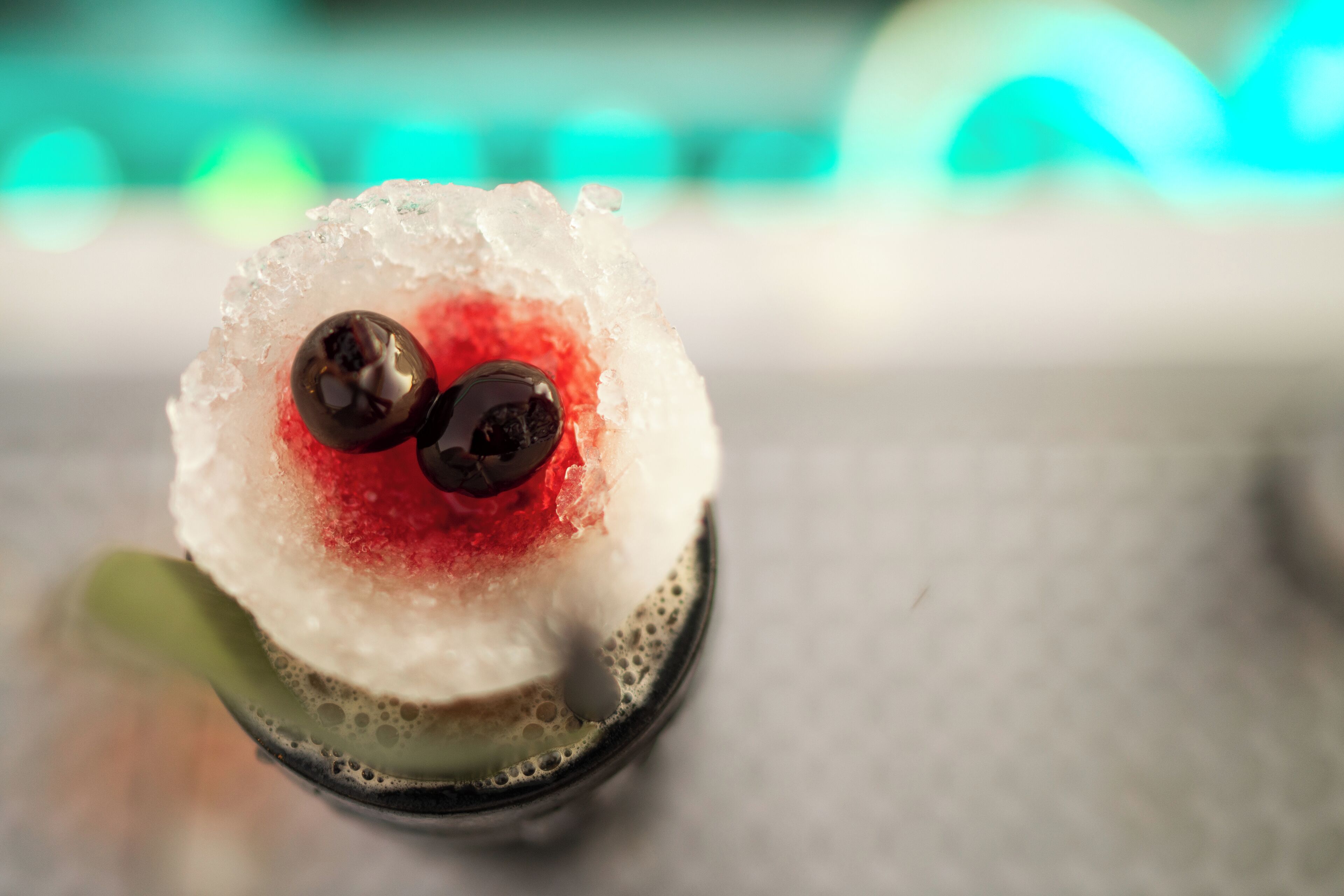A close-up of a cocktail with ice and two olives.