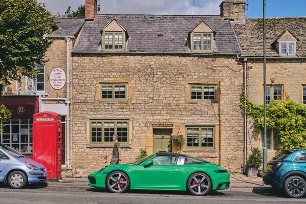 A stone building with a green car parked in front. - Coniston House (Cheltenham)
