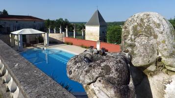 Een buitenzwembad, een verwarmd zwembad en ligstoelen