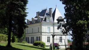 A large, historic building with multiple chimneys and a prominent tower. - Chateau Du Mas - Classic, Elegant, Beautiful (Dignac)
