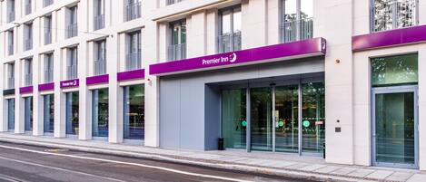 A modern hotel building with multiple floors, large windows, and a prominent 'Premier Inn' sign.