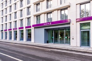 A modern hotel building with multiple floors, large windows, and a prominent 'Premier Inn' sign.