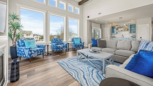 A spacious living room with large windows, a fireplace, and a view of the city. - Coastal Oasis in Corolla + Private Pool + Near the Beach (Corolla)
