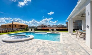 A swimming pool with a hot tub, surrounded by a patio area with outdoor seating. - Beautiful Villa with first class amenities on Encore Resort at Reunion, Orlando Villa 4708 (Orlando)