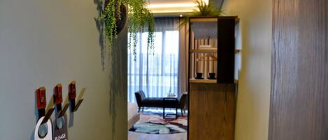 A modern interior with a wooden cabinet, a hanging plant, and a sign on the wall.