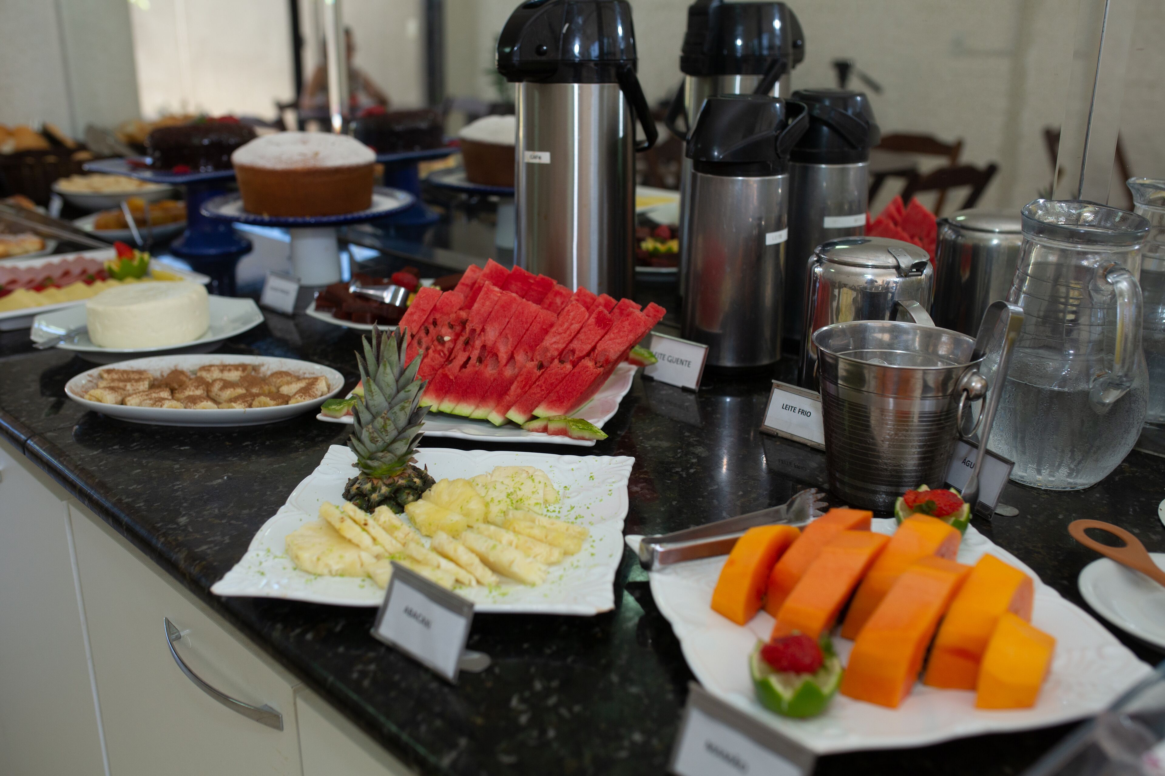 A buffet with various food items including watermelon, pineapple, and cheese.
