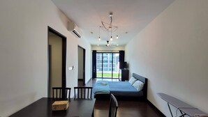 Una habitación de hotel moderna con cama, una mesa de comedor con sillas, ventilador de techo y vistas al exterior.