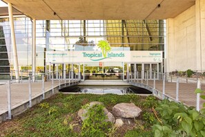 A hotel entrance with a sign reading "Tropical Islands" and a palm tree logo. - Tropical Islands Resort (Krausnick-Gross Wasserburg)