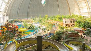 Ein großer Indoor-Freizeitpark mit zahlreichen Wasserrutschen, einer Kuppelkonstruktion und verschiedenen Attraktionen.