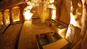 Relax in a tranquil space surrounded by natural rock formations and a small pool.