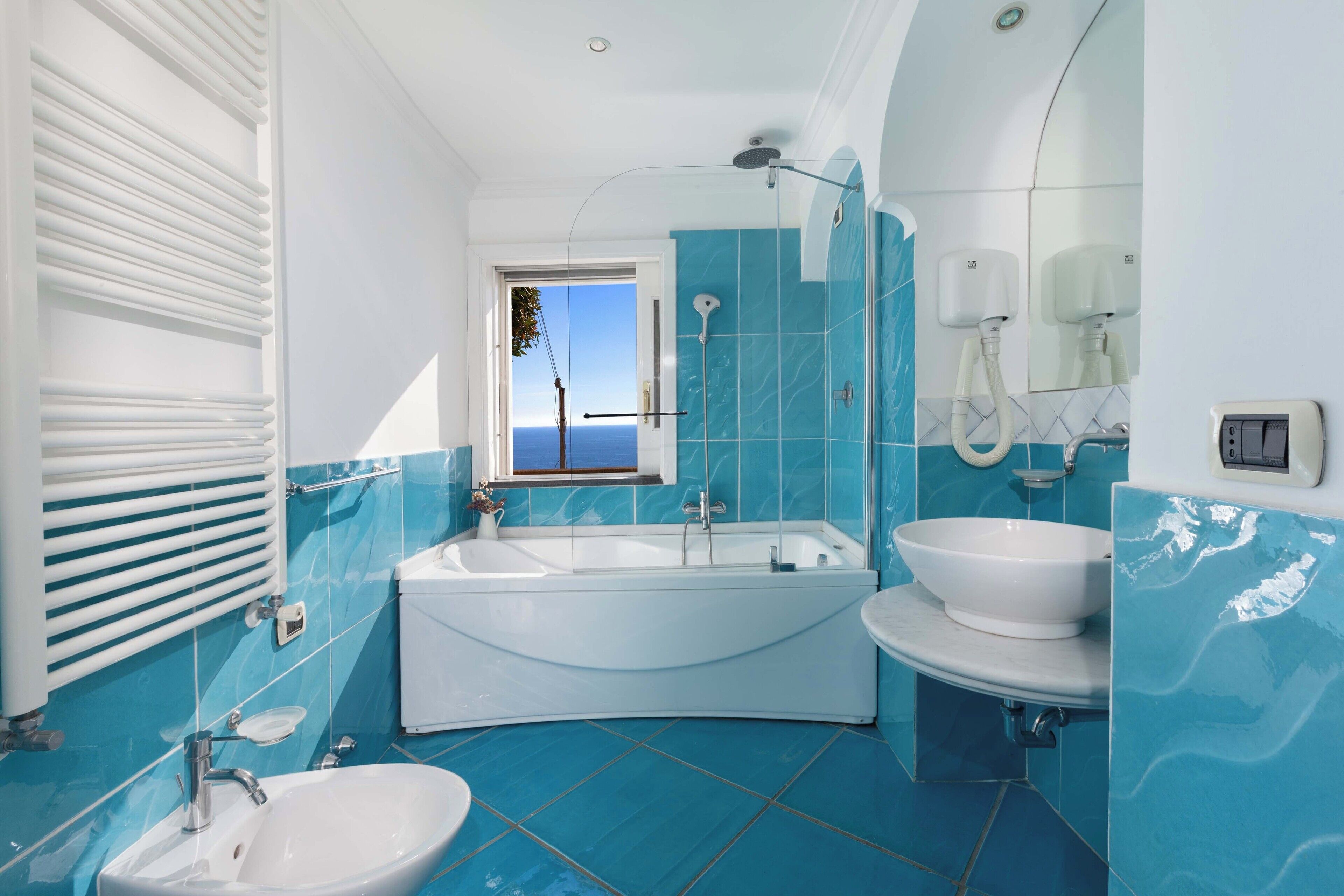 A modern bathroom with a bathtub, a sink, and a large mirror.