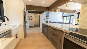 Una cocina moderna con una isla central, armarios de madera y una campana extractora de acero inoxidable.