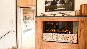 A modern interior with a fireplace, wooden paneling, and a framed photograph on the wall. - Hotel & Gasthof Wagner (Aichach)