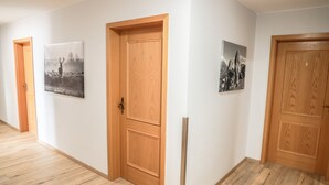 A hallway with wooden doors and two framed pictures on the walls. - Hotel & Gasthof Wagner (Aichach)