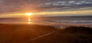 A sunset over a beach with the sun reflecting on the water. - Ocean Front Condo! (North Myrtle Beach)