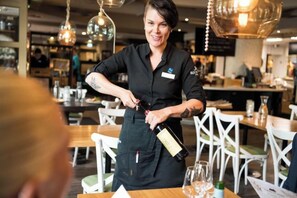 A person pouring a drink into a glass at a restaurant. - Original Sokos Hotel Seurahuone Savonlinna (Savonlinna)