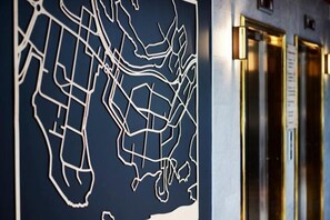 Une carte accrochée au mur, un ascenseur et une porte avec une pancarte.