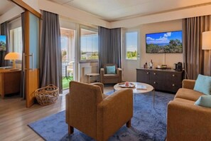 A hotel room with a sofa, armchair, TV, and a balcony with a view. - Original Sokos Hotel Seurahuone Savonlinna (Savonlinna)