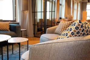 A modern interior with sofas and a round table, large windows, and a view of the outdoors. - Original Sokos Hotel Seurahuone Savonlinna (Savonlinna)