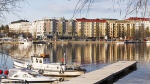 Une vue sur le front de mer, avec un quai, des bateaux et des bâtiments le long de la rivière.