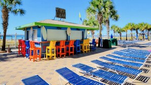 A beach bar with colorful chairs and a sign that reads "TIKI BAR". - Cooks Beach Getaway LLC (Panama City Beach)