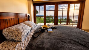 A bed with a patterned bedspread, a hat, a camera, and a book on it. - Family_friendly beach house  (Jama)