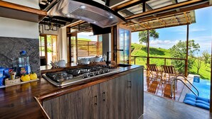 A kitchen with a large island, a view of a pool, and a dining area with outdoor seating. - Family_friendly beach house  (Jama)