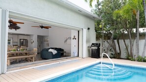 A pool area with a hot tub, wooden deck, and a view of the backyard. - SOUTHERNMOST SWIM AND SOCIAL CLUB  (Key West)