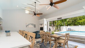 A modern kitchen with a dining area, a pool, and a view of the outdoors. - SOUTHERNMOST SWIM AND SOCIAL CLUB  (Key West)