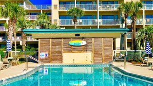 A hotel with a pool, multiple balconies, and palm trees. - Escape to the beach! (Destin)