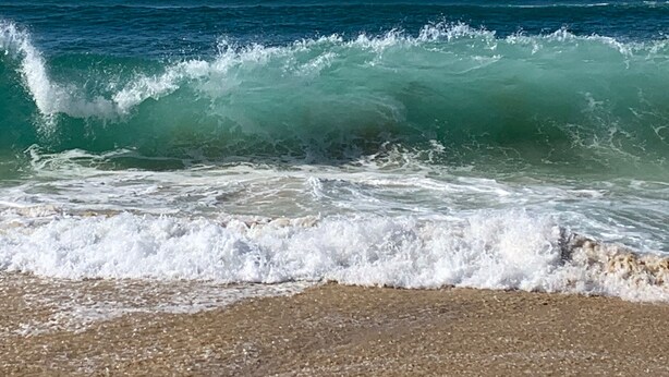 A beach with waves crashing onto the shore.