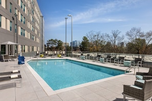 Relax by the pool surrounded by comfortable lounge chairs and umbrellas.