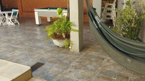 A covered outdoor area with a pool table, a hammock, and a potted plant. - Spacious house with accessibility.  A few meters from the beach.  (SP)