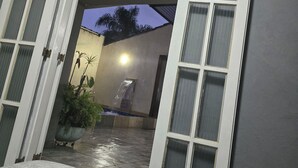 An open doorway leading to a covered outdoor area with a potted plant and a water feature. - Spacious house with accessibility.  A few meters from the beach.  (SP)