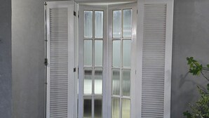 A corner room with a stone tile floor, a white door with frosted glass panels, and a grey wall. - Spacious house with accessibility.  A few meters from the beach.  (SP)