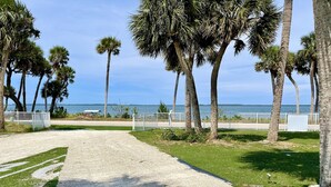 A gravel path leading to a white fence overlooking a body of water. - 3 Bedroom 3 Bath  a waterfront 3 Acre Home close to Downtown and Beaches. (Fort Pierce)