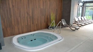 A spa area with a hot tub, a wooden wall, and lounge chairs. - Apartment Kolberg 10 Minutes Walk From the Beach (Kolobrzeg)