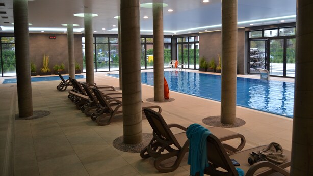 An indoor swimming pool area with lounge chairs and a view of the pool. - Apartment Kolberg 10 Minutes Walk From the Beach (Kolobrzeg)