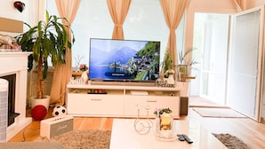 Ein Wohnzimmer mit Fernseher, Kamin, Sofa und Couchtisch.