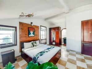 A bedroom with a bed, a wooden headboard, a window, and a wardrobe.