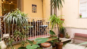 A balcony with potted plants, a statue, and a bench. - Casa Linnéa Vacanze, Central apartment, WIFI, Printer & Scanner, A/C, heating (Roma)