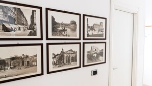 Sechs gerahmte Schwarz-Weiß-Fotografien an einer Wand, die verschiedene historische Gebäude und Szenen zeigen.