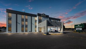 A modern building with a sign for Home Towne Studios. - HomeTowne Studios By Red Roof Newport News – Hampton West (Newport News)