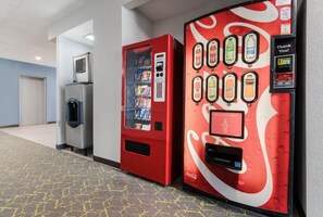 En gang med en rød Coca-Cola automt og en vanddispenser.